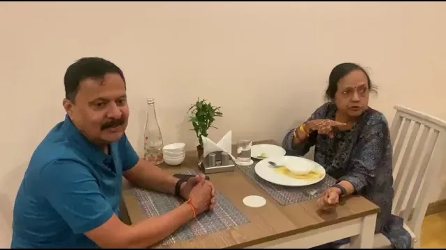 Video still: two guests at a table in the dining hall after a meal