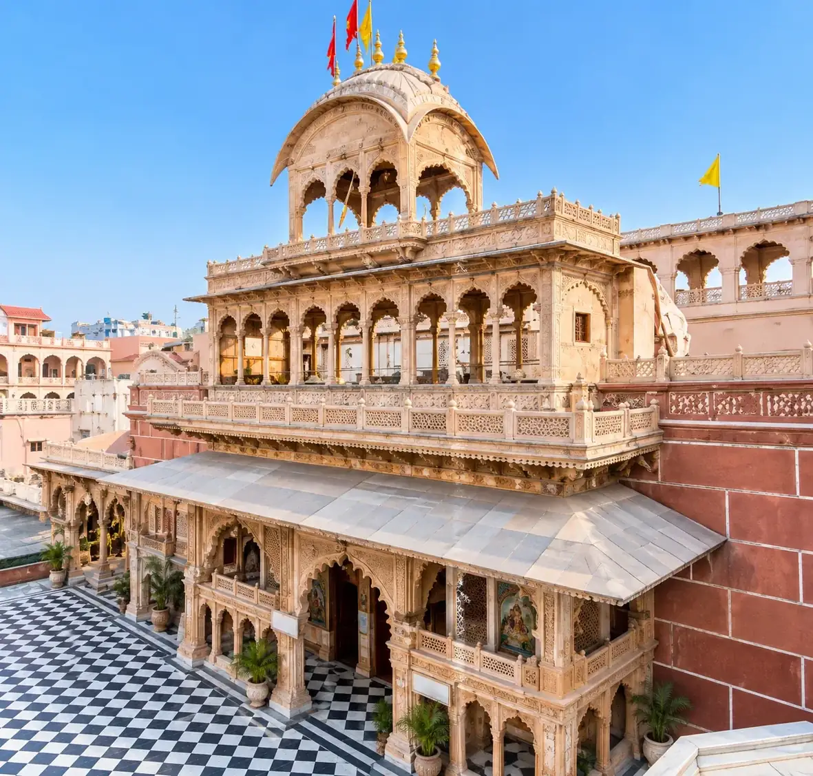 Banke Bihari Temple, Vrindavan: the sandstone facade with its carved arcades and flag-topped dome above the chequered courtyard
